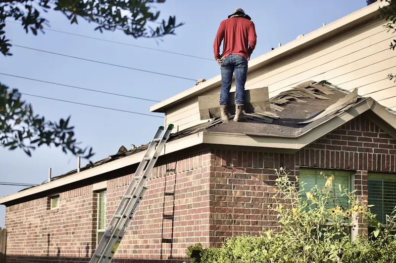 Professional roofer working on a residential roof in Little Central America